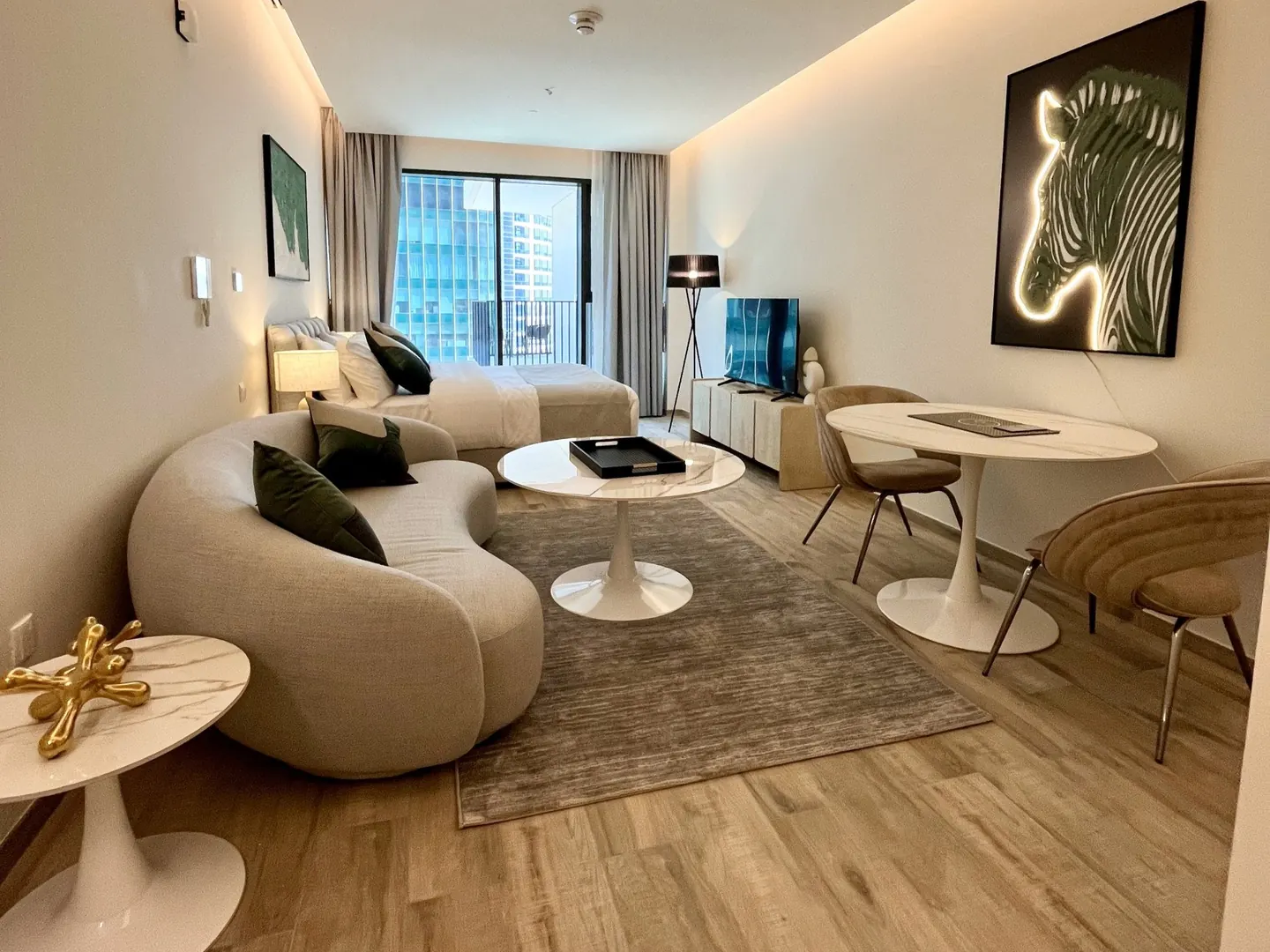 Furnished studio at Ahad Residences: living area, dining table and the bed by the window